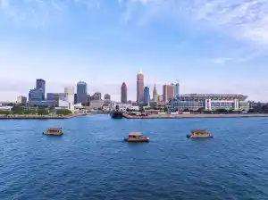 City skyline with boats on a lake under a clear sky.