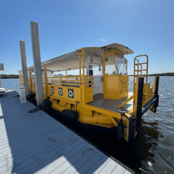 A yellow ferry docked at a pier on a sunny day.
