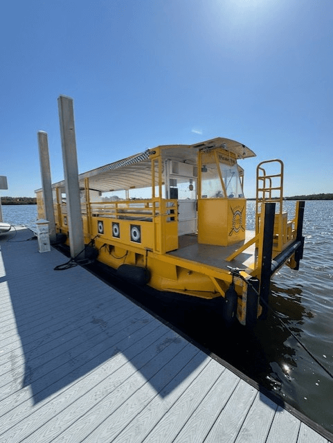 Yellow ferry docked at pier under clear blue sky.